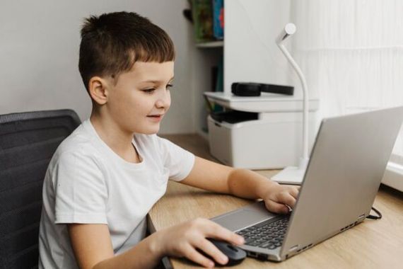 side view boy home using laptop scaled e1770042338292